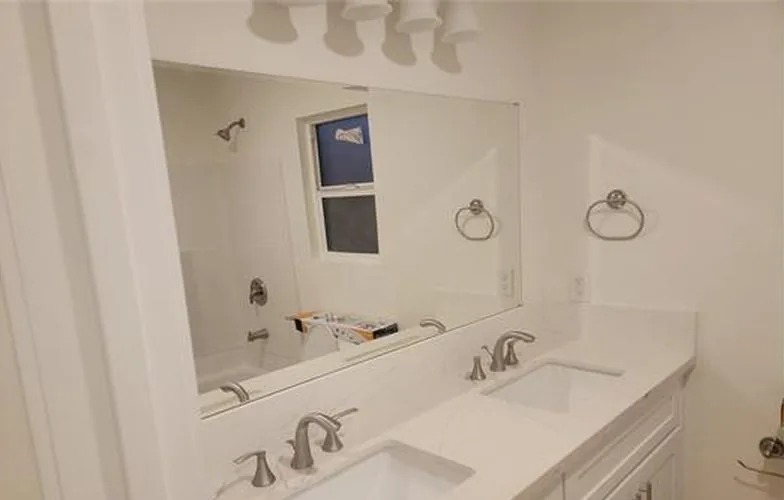 Baño con un mueble de doble lavabo y un espejo amplio