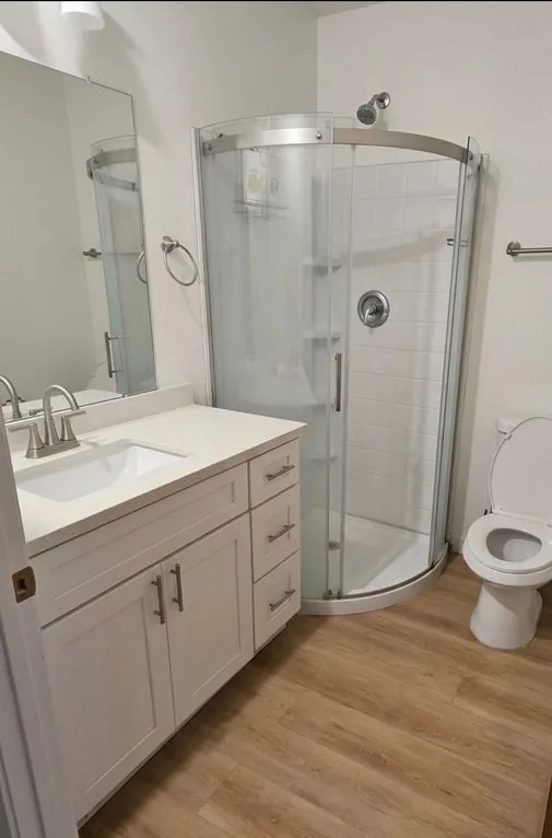 Baño con regadera de vidrio curvo y un lavabo blanco